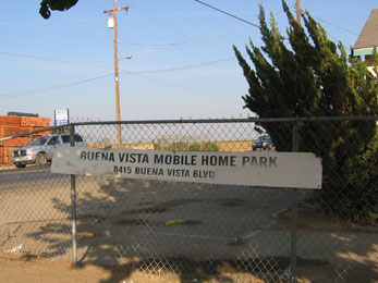 sign for buena Vista Mobile Home Park attached to wire fence at entrance to mobile home park